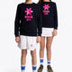 Boy and girl wearing the Osaka kids sweater in navy with pink logo. Full front view