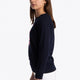 Girl wearing the Osaka kids sweater in navy with pink logo. Side view