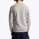Boy wearing the Osaka kids sweater in grey with pink logo. Back view