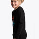 Girl wearing the Osaka kids pixo sweater in black with orange and blue logo. Side view