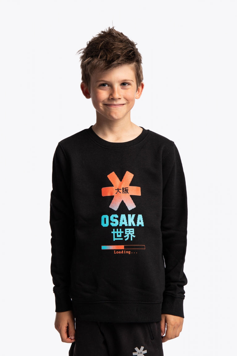 Boy wearing the Osaka kids pixo sweater in black with orange and blue logo. Front view