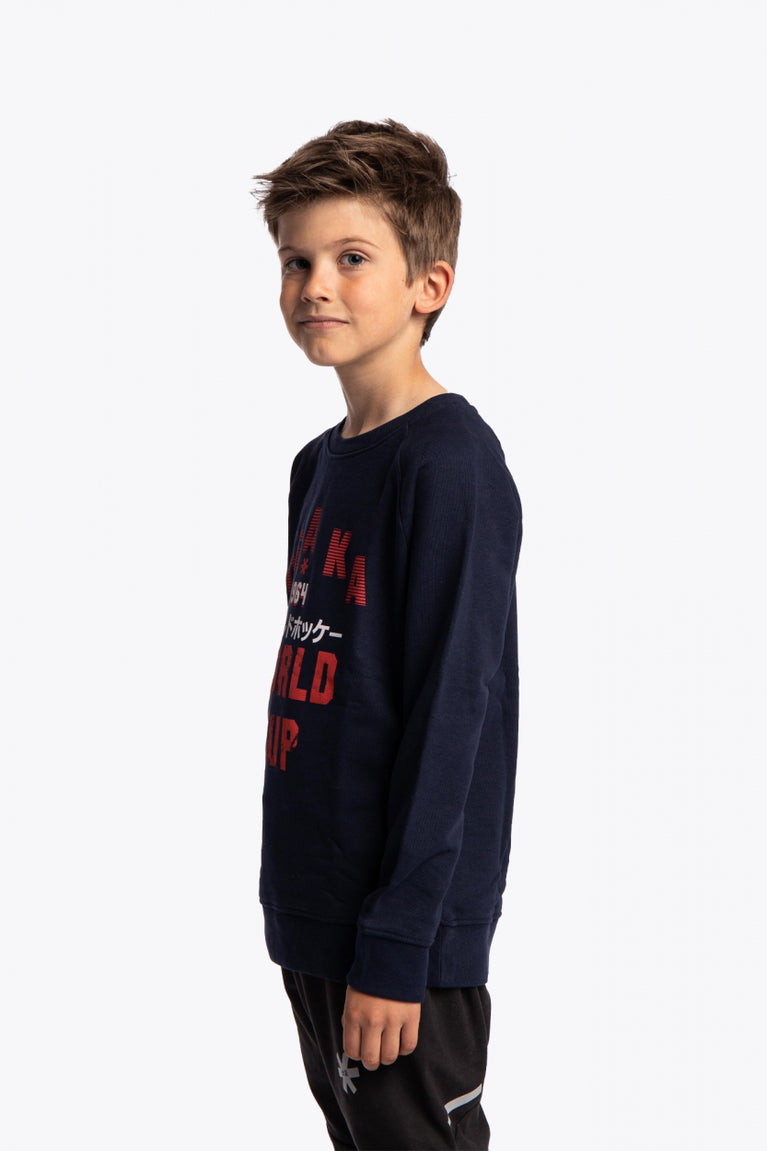 Boy wearing the Osaka kids worldcup sweater in navy with orange logo. Side/front view