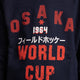 Osaka kids worldcup sweater in navy with orange logo. Detail view logo