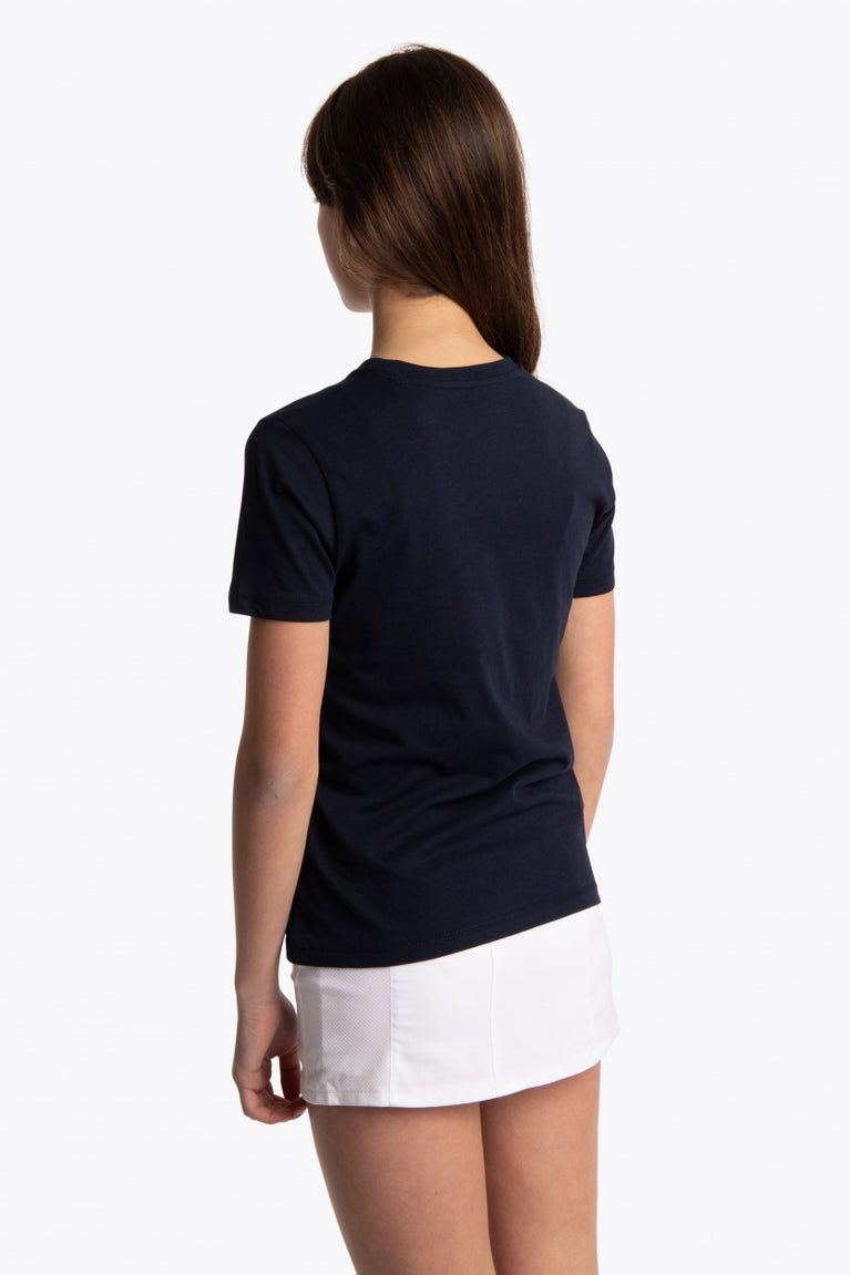 Girl wearing the Osaka kids tee short sleeve navy with logo in blue. Side/back view