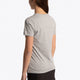 Girl wearing the Osaka kids tee short sleeve grey with logo in blue. Side/back view