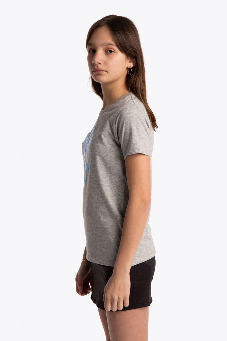 Girl wearing the Osaka kids tee short sleeve grey with logo in blue. Side view
