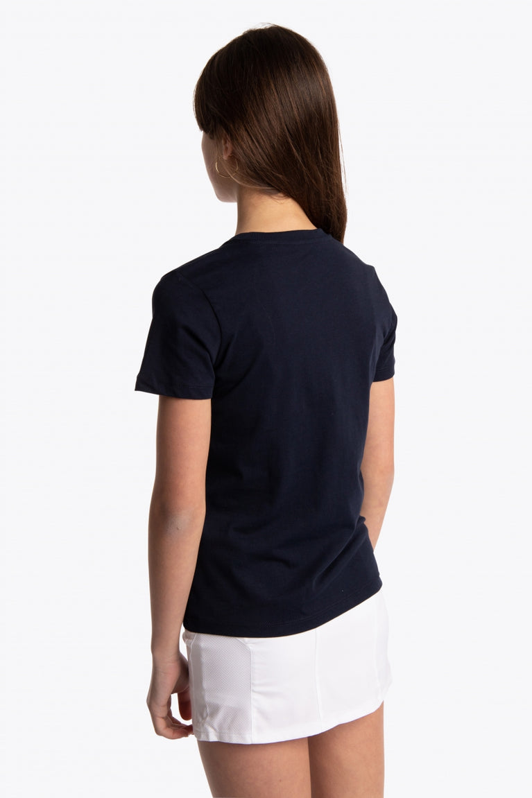 Girl wearing the Osaka kids tee short sleeve navy with logo in green. Back view