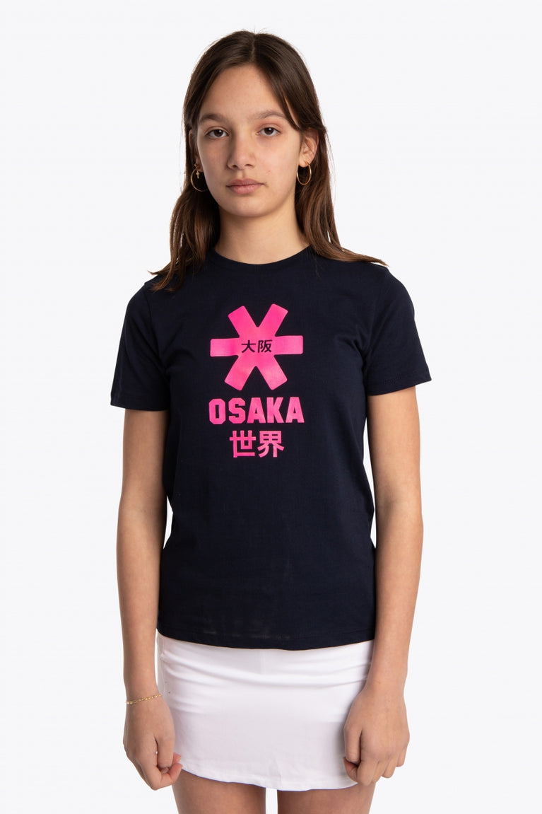 Girl wearing the Osaka kids tee short sleeve navy with logo in pink. Front view