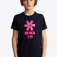 Boy wearing the Osaka kids tee short sleeve navy with logo in pink. Front view