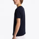 Boy wearing the Osaka kids tee short sleeve navy with logo in pink. Side view