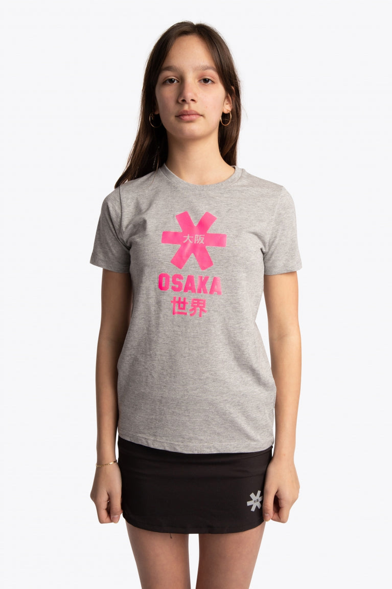 Girl wearing the Osaka kids tee short sleeve grey with logo in pink. Front view