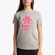 Girl wearing the Osaka kids tee short sleeve grey with logo in pink. Front view