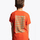 Boy wearing the Osaka kids service games tee short sleeve orange with logo in green. Back view