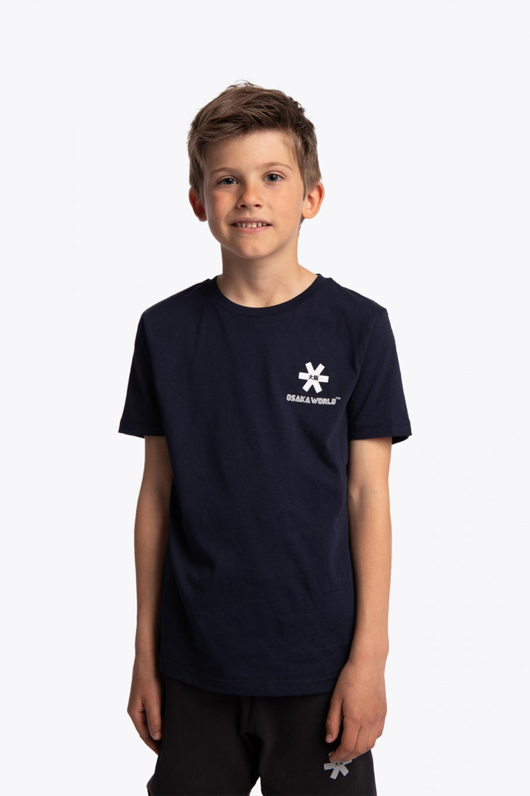 Boy wearing the Osaka kids service games tee short sleeve navy with logo in white. Front view