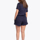 Woman wearing the Osaka women shorts in navy with white logo. Back view