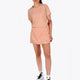 Woman wearing the Osaka women ball skort in peach with logo in grey. Front view
