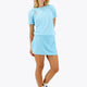 Woman wearing the Osaka women ball skort in light blue with logo in grey. Front view