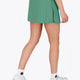 Woman wearing the Osaka women ball skort in green with logo in grey. Back view