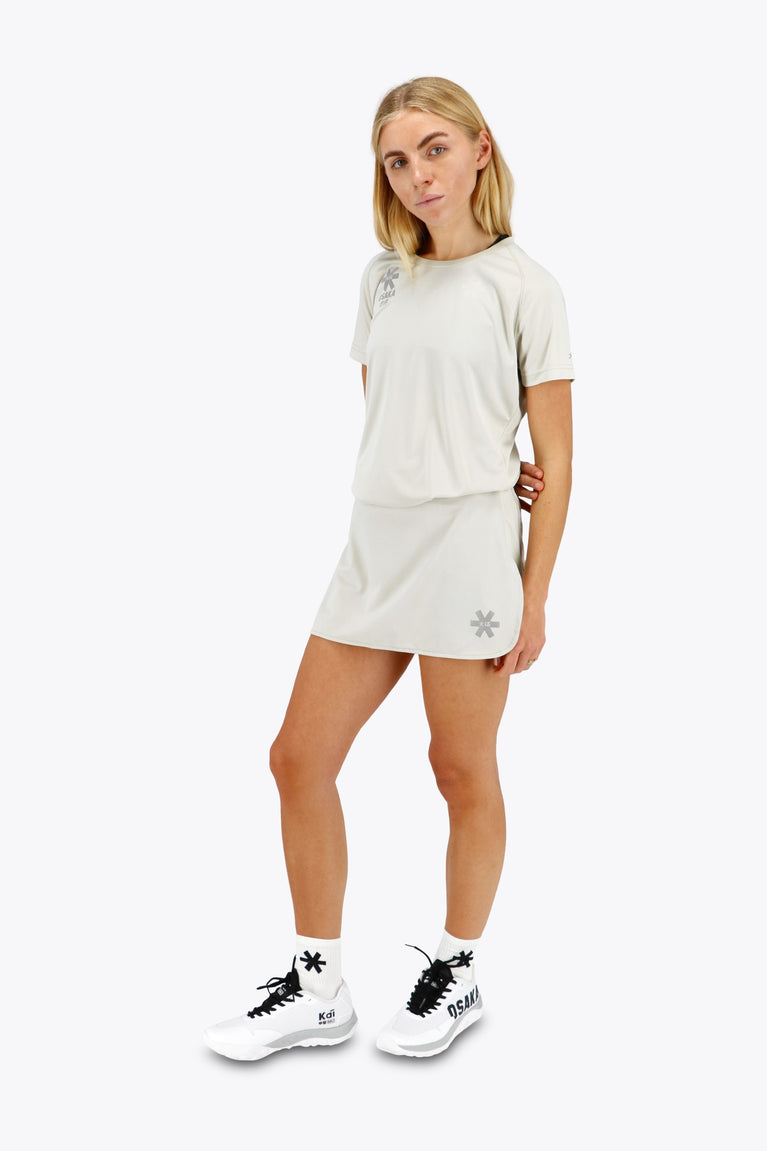 Woman wearing the Osaka women ball skort in light grey with logo in grey. Front view