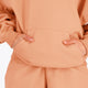 Osaka women half zip sweater in peach with white logo. Front view