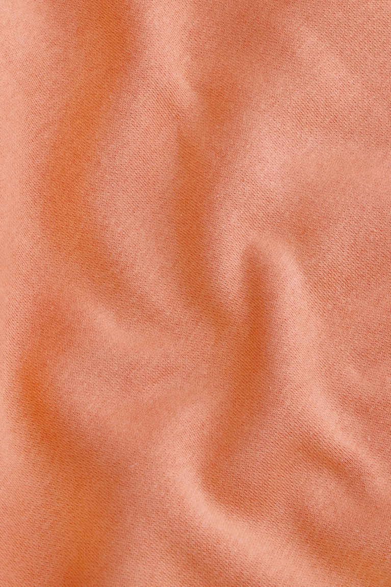 Osaka women half zip sweater in peach with white logo. Detail fabric view