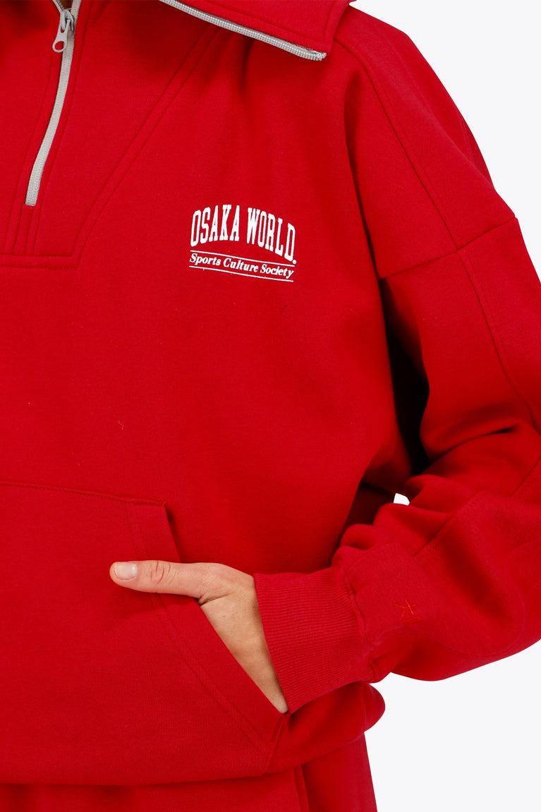 Osaka women half zip sweater in red with white logo. Front detail sleeve view