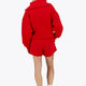 Woman wearing the Osaka women half zip sweater in red with white logo. Back view