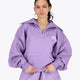 Woman wearing the Osaka women half zip sweater in light purple with white logo. Front view