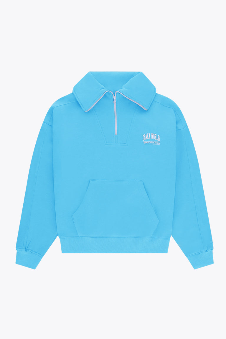 Osaka women half zip sweater in light blue with white logo. Front flatlay view