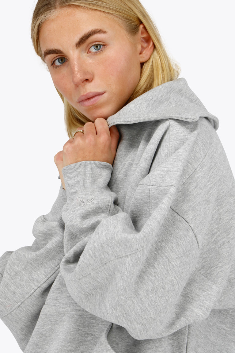 Osaka women half zip sweater in heather grey with white logo. Side detail sleeve view