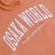 Osaka women hoodie in peach with white logo. Front detail logo view