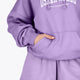Woman wearing the Osaka women hoodie in light purple with white logo. Front detail sleeve view
