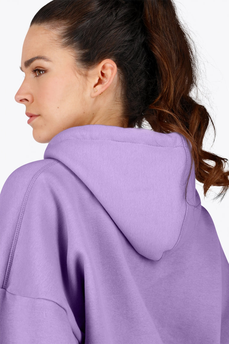 Woman wearing the Osaka women hoodie in light purple with white logo. Back detail cap view