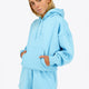 Woman wearing the Osaka women hoodie in light blue with white logo. Front view