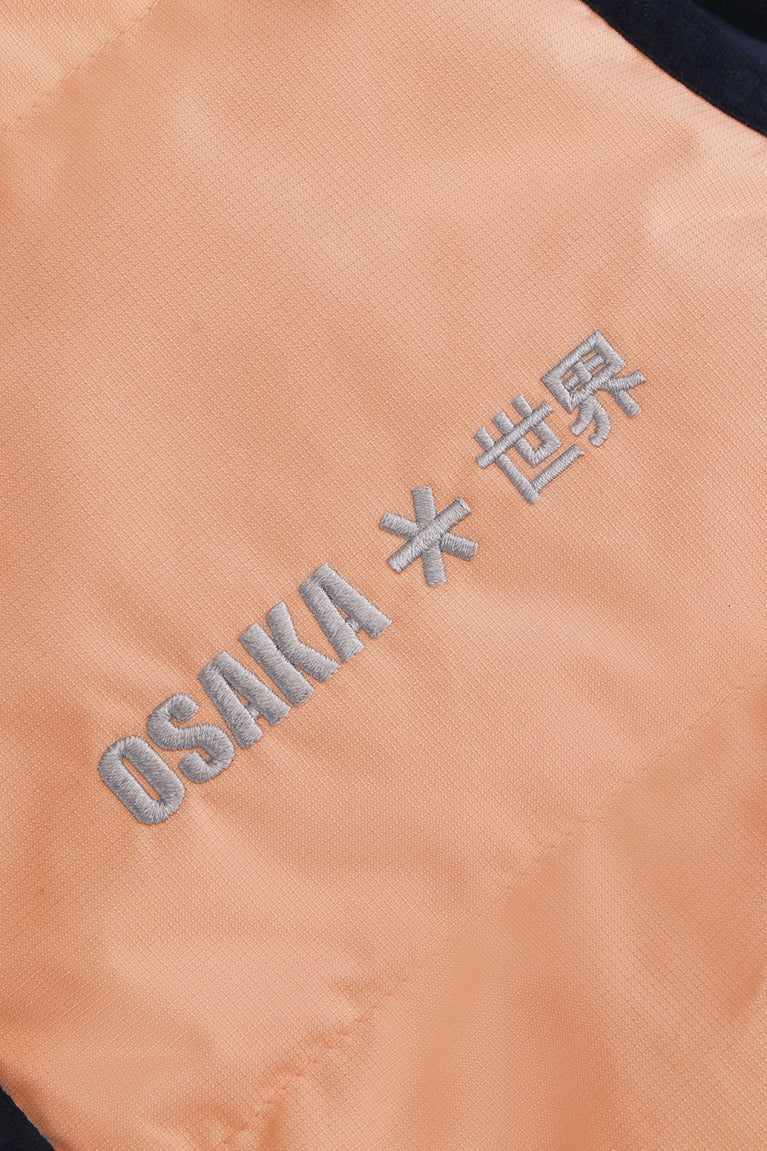 Osaka women padded gilet in peach with grey logo. Front detail logo view