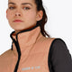 Woman wearing the Osaka women padded gilet in peach with grey logo. Front detail logo view