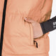 Woman wearing the Osaka women padded gilet in peach with grey logo. Front detail pocket view