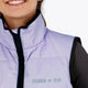 Woman wearing the Osaka women padded gilet in purple with grey logo. Front detail logo view