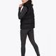 Woman wearing the Osaka women padded gilet in black with white logo. Back view