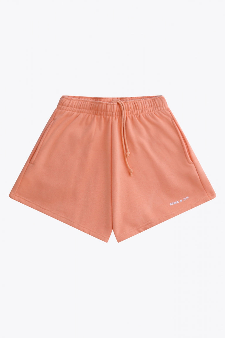 Osaka women shorts in peach with logo in white. Front flatlay view