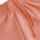 Osaka women shorts in peach with logo in white. Front flatlay detail cords view