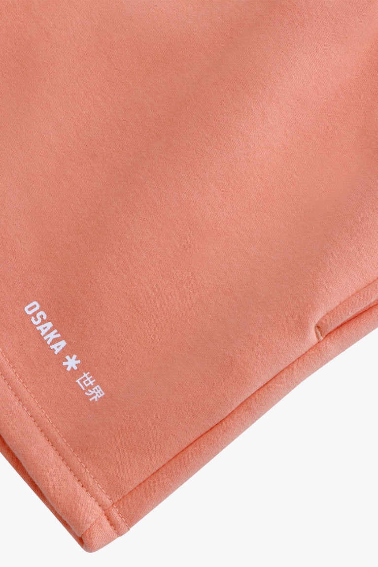 Osaka women shorts in peach with logo in white. Front flatlay detail logo view
