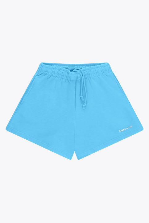 Osaka women shorts in light blue with logo in white. Front flatlay view