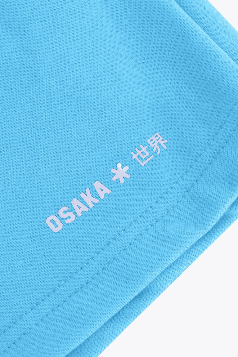 Osaka women shorts in light blue with logo in white. Front flatlay detail logoview