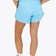 Woman wearing the Osaka women shorts in light blue with logo in white. Back view