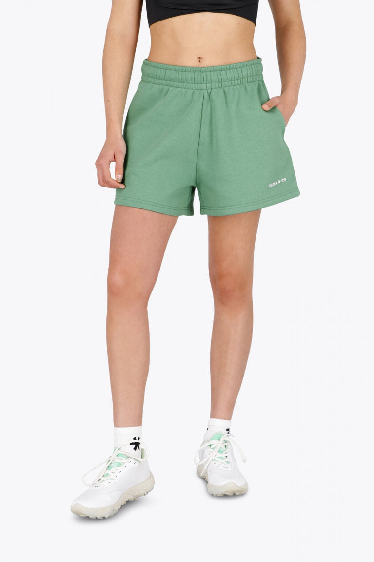 Woman wearing the Osaka women shorts in green with logo in white. Front view