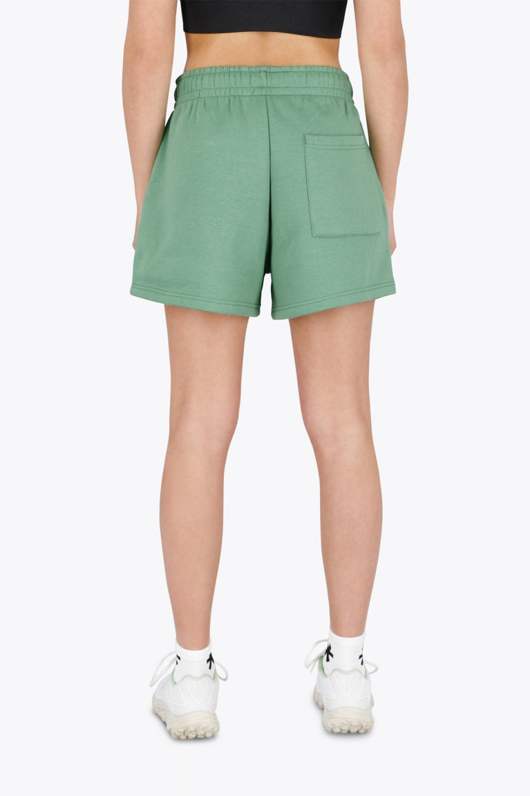 Woman wearing the Osaka women shorts in green with logo in white. Back view