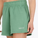 Woman wearing the Osaka women shorts in green with logo in white. Front view