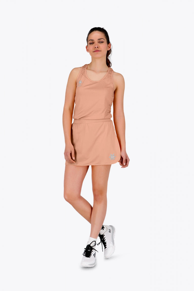 Woman wearing the Osaka women singlet in peach with logo in grey. Front view
