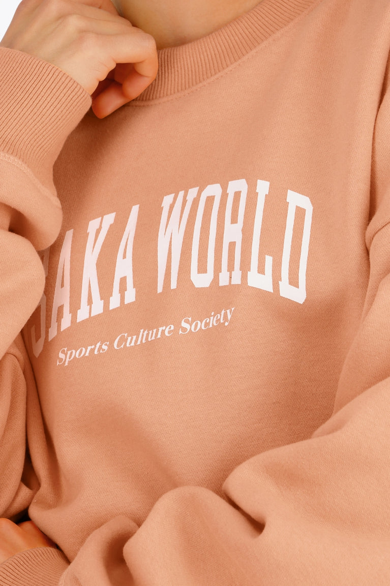 Osaka women sweater in peach with logo in white. Front detail logo view